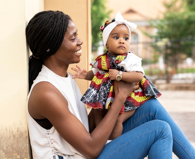 Mãe africana segurando uma garotinha, tiro médio