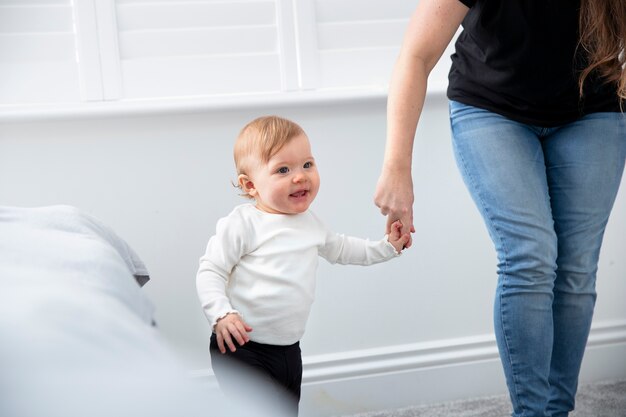 Mãe ajudando criança a andar em casa