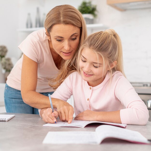 Mãe ajudando filha com lição de casa