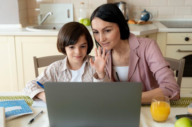 Foto grátis mãe ajudando o filho em uma aula online