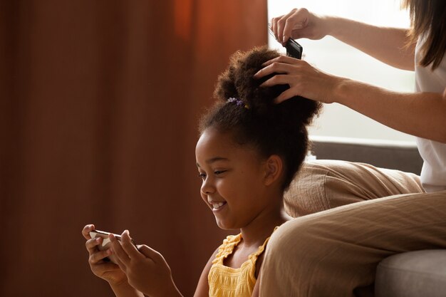 Mãe ajudando seu filho a pentear o cabelo afro