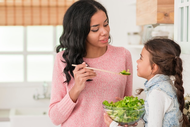 Mãe alimentando sua salada de filha