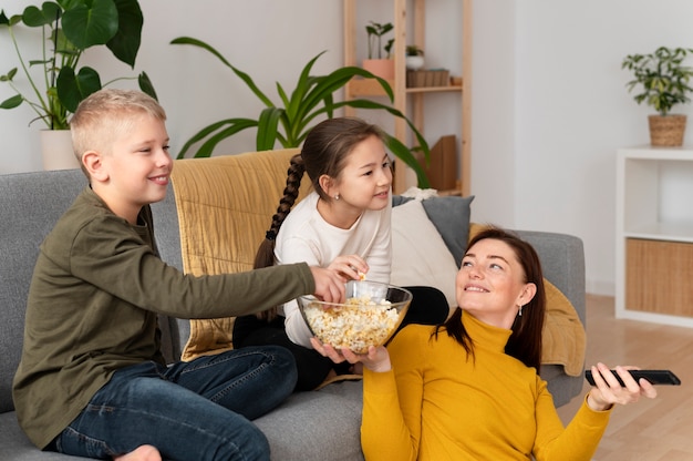 Foto grátis mãe assistindo televisão com seus filhos