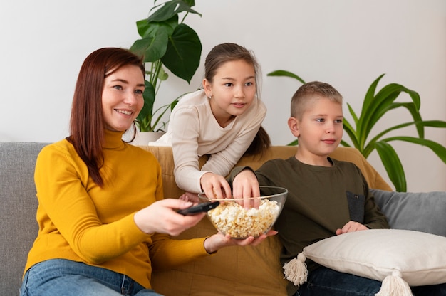 Foto grátis mãe assistindo televisão com seus filhos