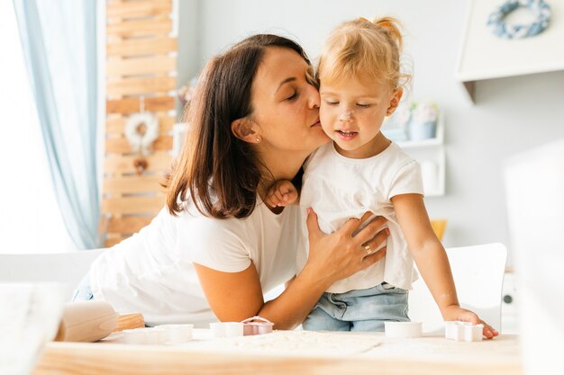 Mãe beijando menina bonitinha