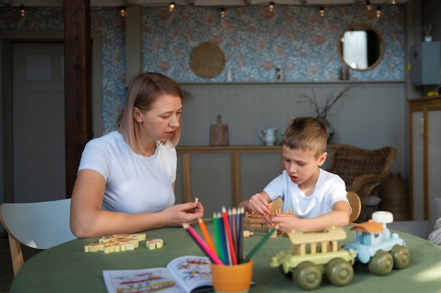 Mãe brincando com seu filho autista usando brinquedos