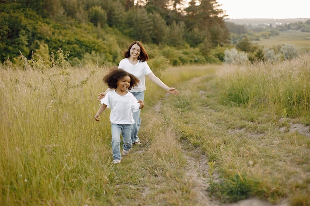 Mãe caucasiana e filha afro-americana correndo juntas