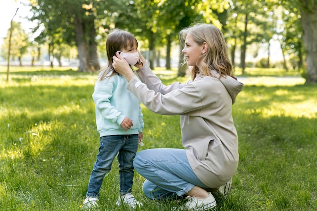 Mãe colocando a máscara médica da filha