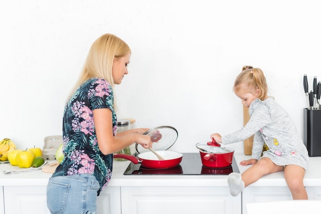 Mãe com a filha na cozinha a cozinhar juntos