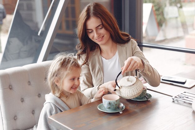 Mãe com a filha sentada em um café