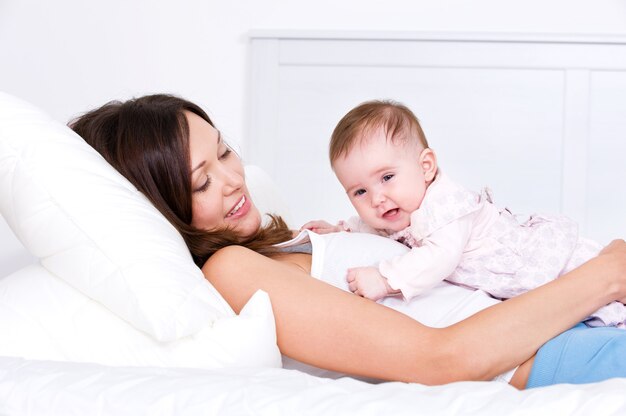 Mãe com bebê deitado na cama