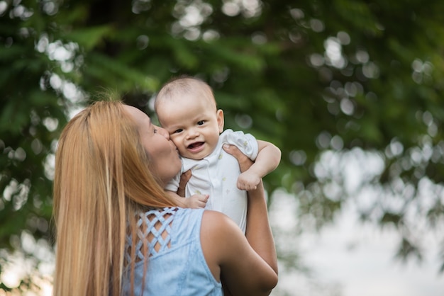 Mãe com bebê, rindo e brincando no parque