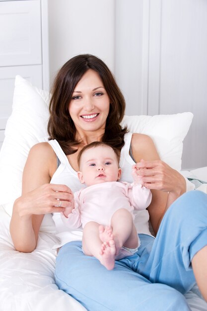Mãe com bebê sentado em casa em roupas casuais