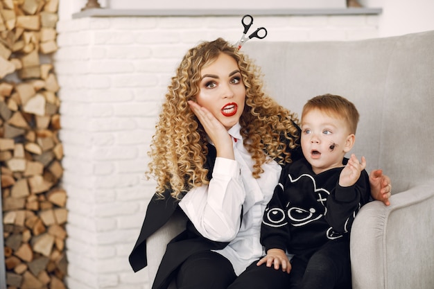 Mãe com criança em fantasias e maquiagem. Família se prepara para a celebração do Halloween.