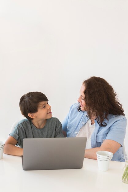 Mãe com criança trabalhando no laptop