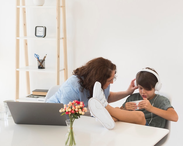 Mãe com criança trabalhando no laptop