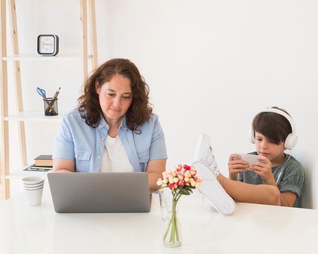 Mãe com criança trabalhando no laptop
