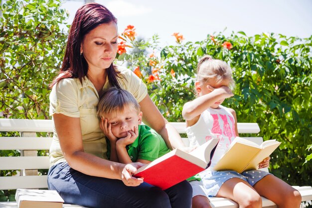 Mãe com crianças lendo livros