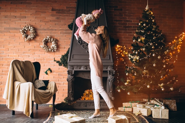 Mãe com daughterby lareira no natal