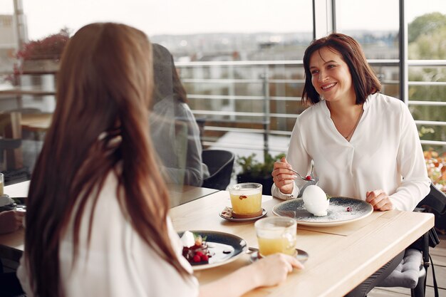 Mãe com filha adulta, sentado em um café