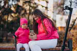 Foto grátis mãe com filha andando de scooter elétrica