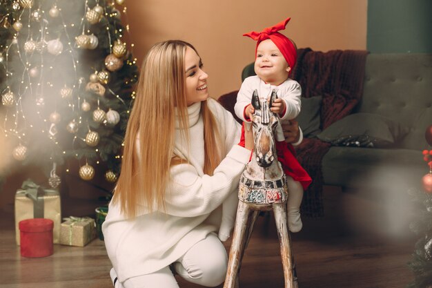 Mãe com filha bonita perto de árvore de Natal