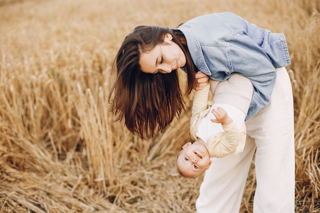 Mãe com filha brincando em um campo de outono