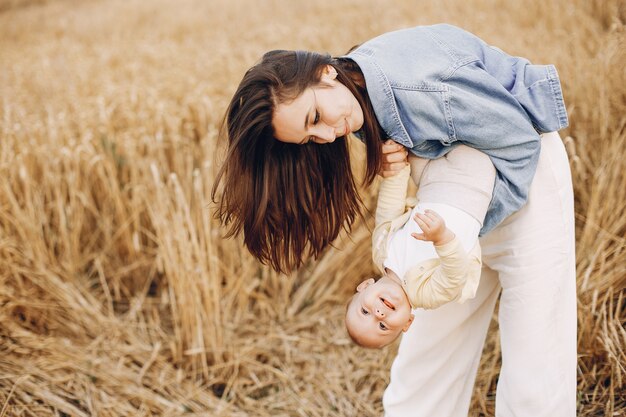 Mãe com filha brincando em um campo de outono