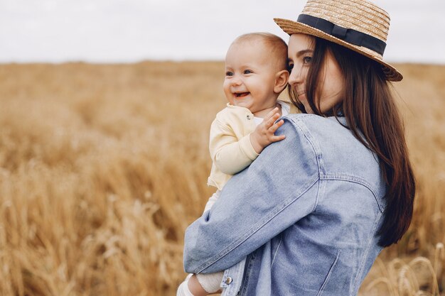 Mãe com filha brincando em um campo de outono