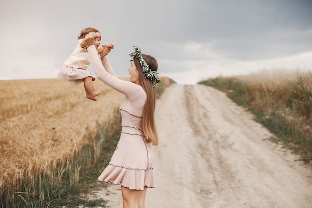 Mãe com filha brincando em um campo de verão