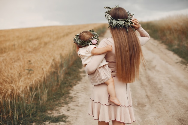 Mãe com filha brincando em um campo de verão