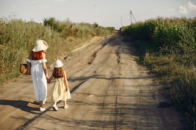 Mãe com filha brincando em um campo de verão