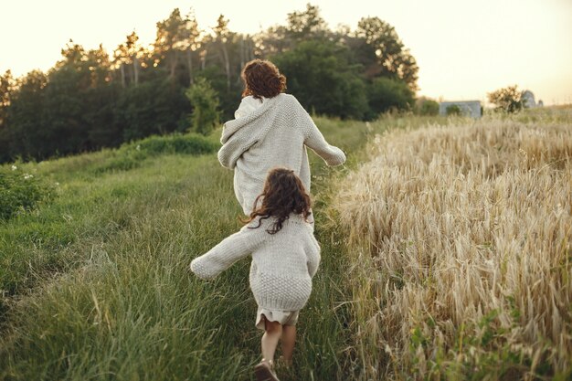 Mãe com filha brincando em um campo de verão