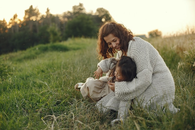 Mãe com filha brincando em um campo de verão