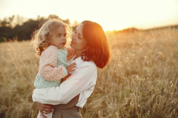 Mãe com filha brincando em um campo de verão