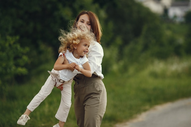 Mãe com filha brincando em um campo de verão