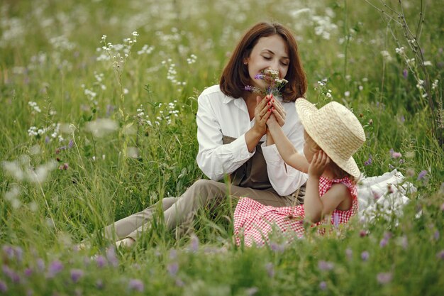 Mãe com filha brincando em um campo de verão