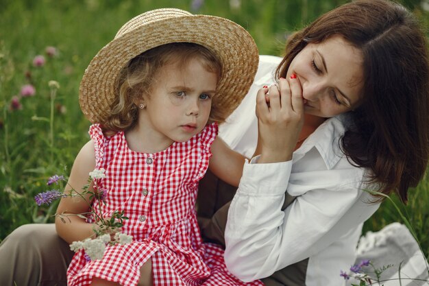 Mãe com filha brincando em um campo de verão