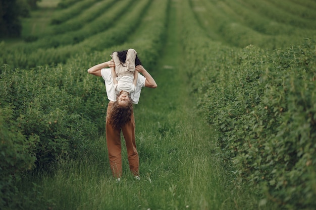 Mãe com filha brincando em um campo de verão