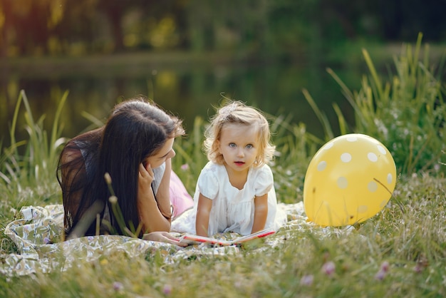 Mãe com filha brincando em um parque de verão