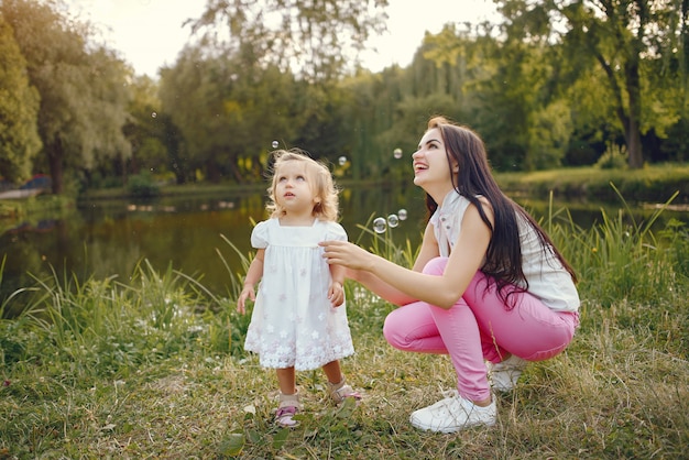 Mãe com filha brincando em um parque de verão