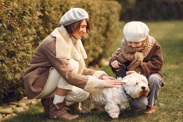 Mãe com filha caminha com um cachorro