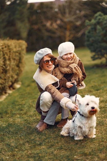 Mãe com filha caminha com um cachorro