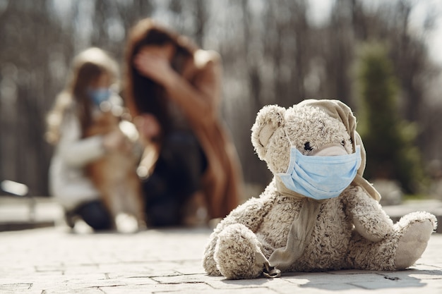 Mãe com filha caminha lá fora em máscaras