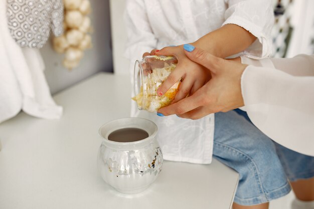 Mãe com filha cozinhando em casa