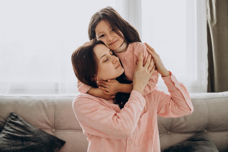 Foto grátis mãe com filha em casa abraçando-se