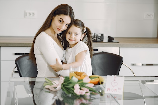 Mãe com filha em casa