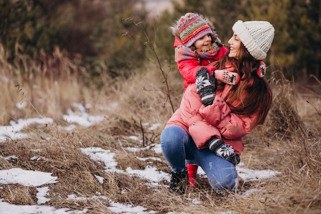 Mãe com filha em uma floresta de inverno