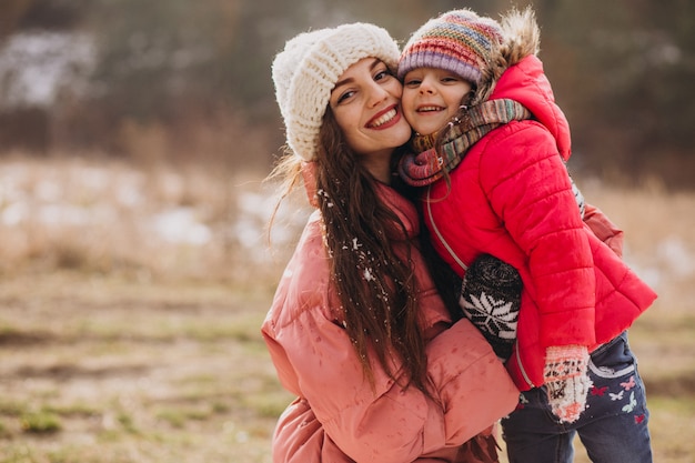 Mãe com filha em uma floresta de inverno