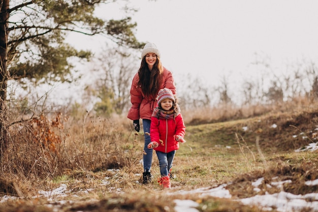 Mãe com filha em uma floresta de inverno